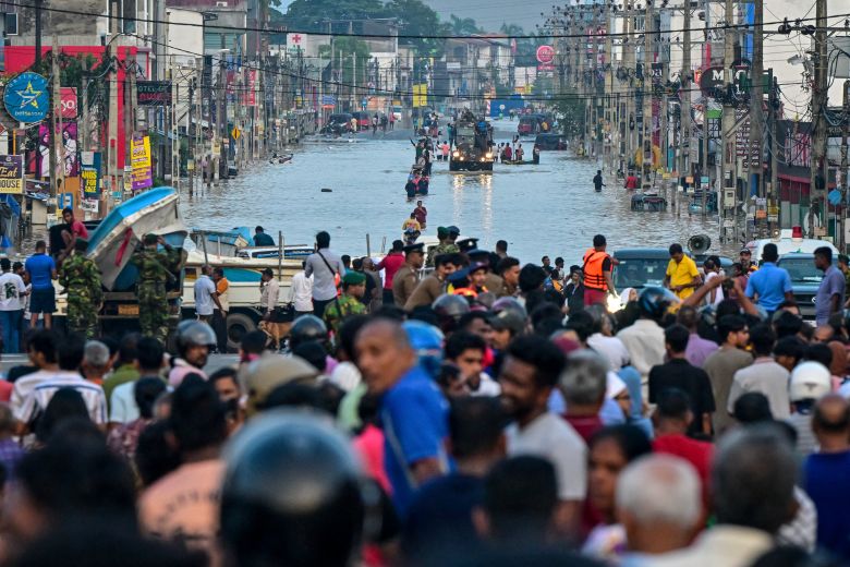 Army personnel ride a truck carrying boats to rescue stranded people in Wellampitiya.