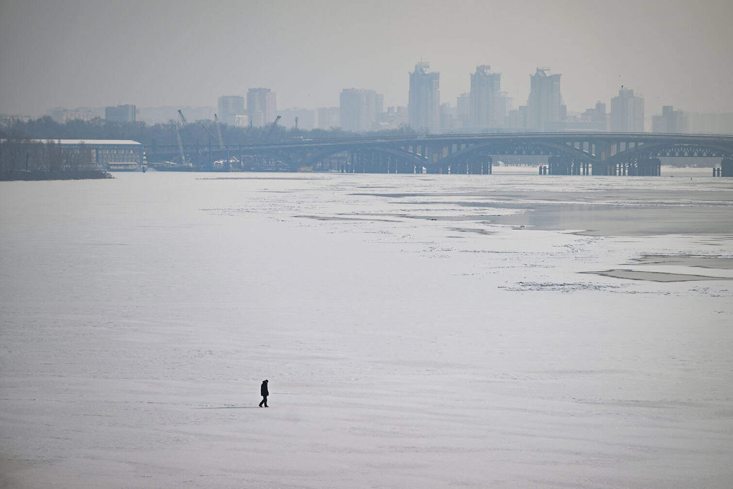 A pedestrian walks across the ice-covered Dnieper River